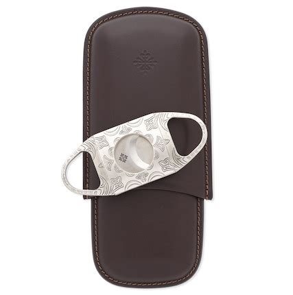 Patek Philippe. A finely engraved stainless steel cigar cutter and 